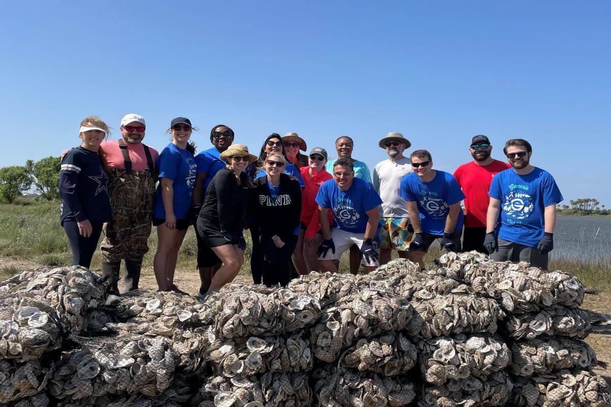 Genesis employees gathered in a group with oyster bags